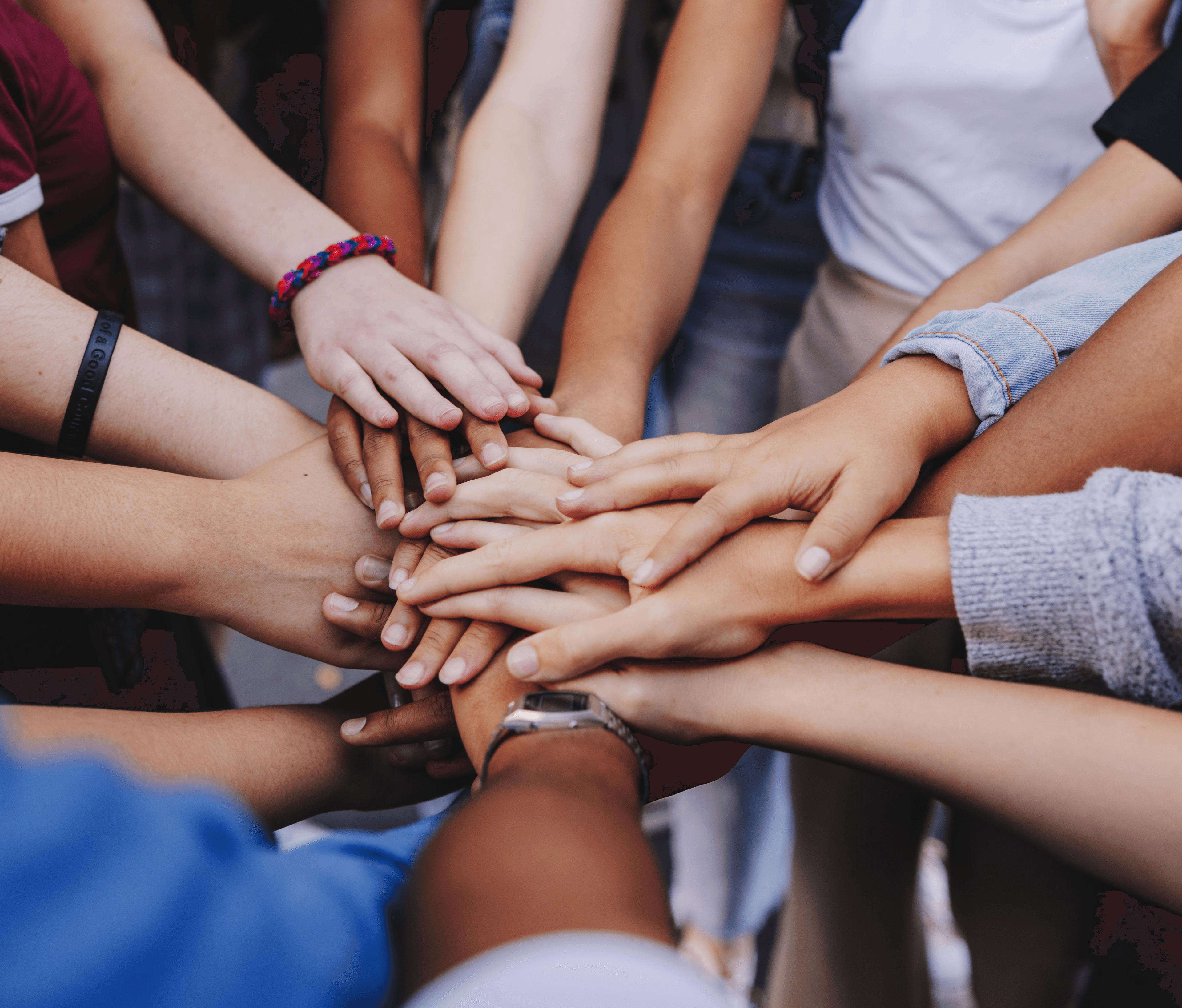 Symbolbild zur Sozialverträglichkeit: Menschen stehen im Kreis und legen in der Mitte ihre Hände aufeinander